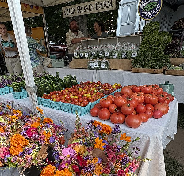 Old Road Farm stand with tomatoes, flowers, and vendors