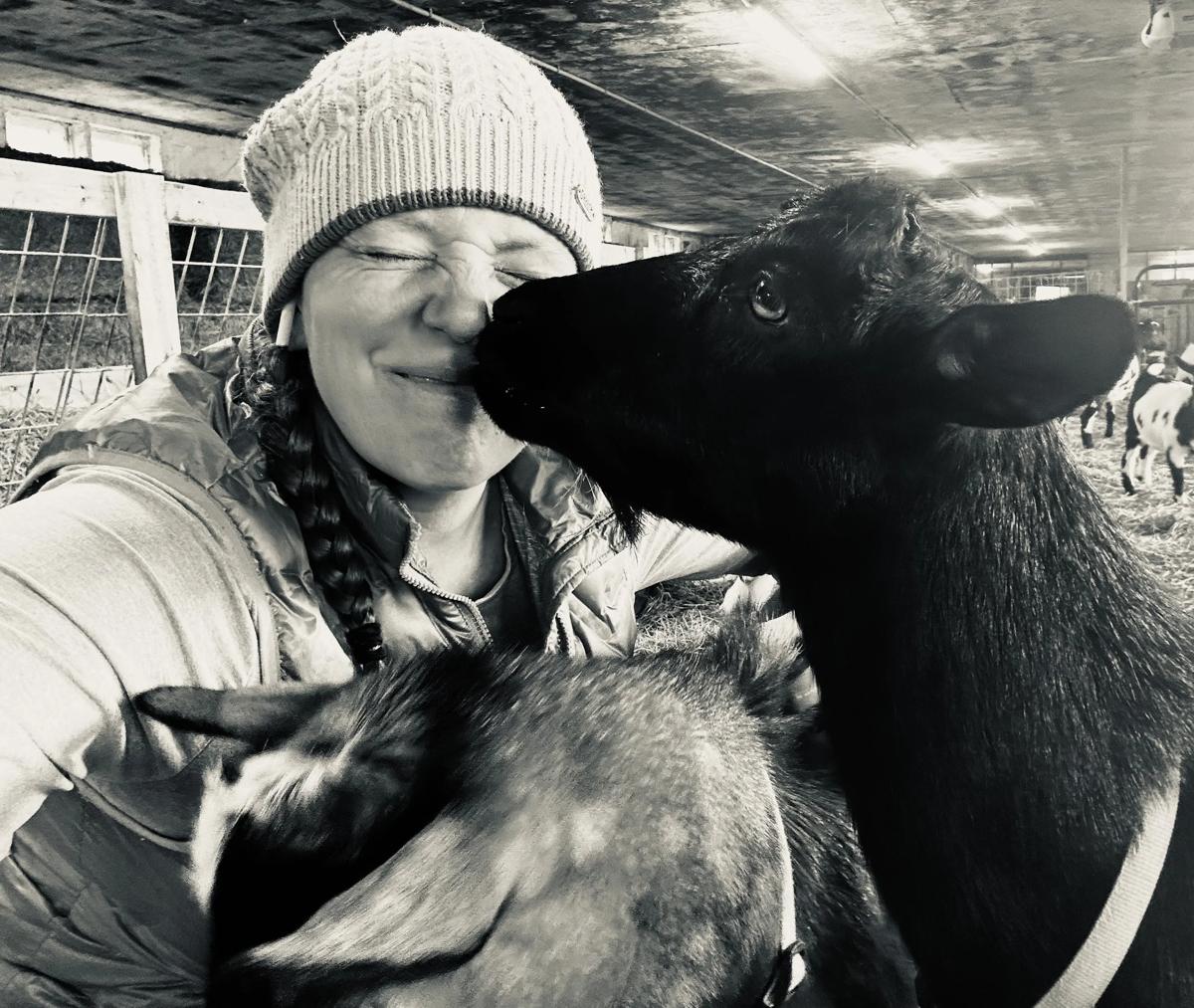 Margaret Aiken gets a kiss from one of her goats.