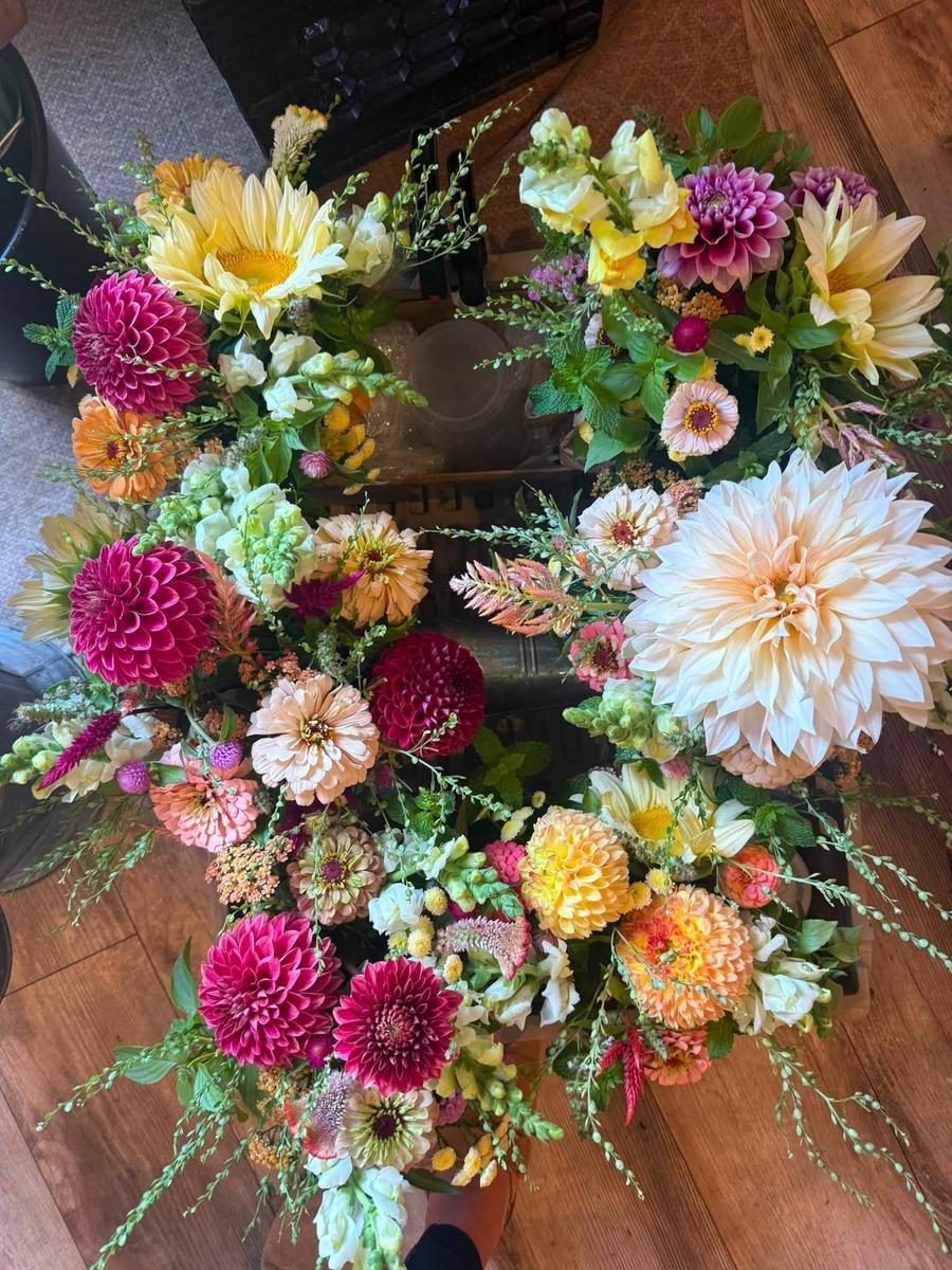 Bouquets built around dahlias in deep magenta, butter yellow, and blush, seen from above.